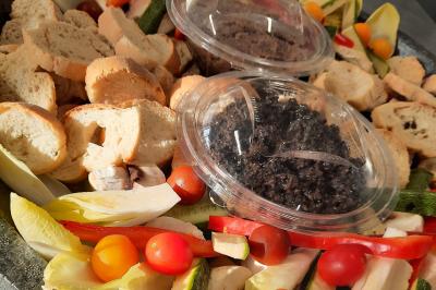 Un couple coupe un gâteau éclairé de bougies étincelantes lors d'une fête dans une salle décorée.