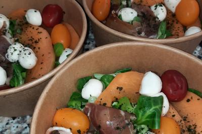 Un couple coupe un gâteau éclairé de bougies étincelantes lors d'une fête dans une salle décorée.