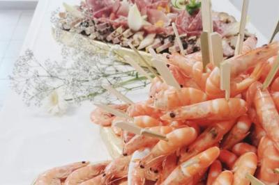 Bouteilles de vin rouge et rosé disposées sur un tonneau en bois, avec une plante en arrière-plan.