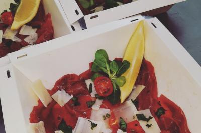 Bouteilles de vin rouge et rosé disposées sur un tonneau en bois, avec une plante en arrière-plan.