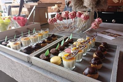 Salle en pierre aménagée pour un événement, avec tables rondes décorées et chaises blanches.