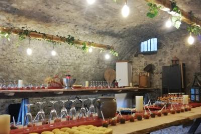 Jardin ensoleillé aménagé pour un événement avec tables hautes, tente blanche et allée décorée de fleurs.