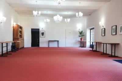 Jardin ensoleillé aménagé pour un événement avec tables hautes, tente blanche et allée décorée de fleurs.