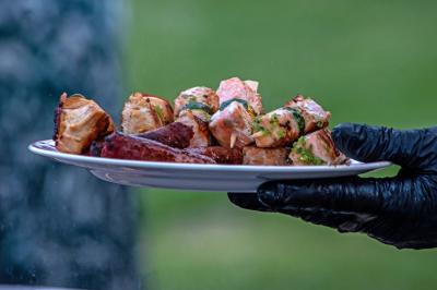 Des jeunes femmes en robes de soirée interagissent avec des résidents d'un établissement, dans une ambiance conviviale.