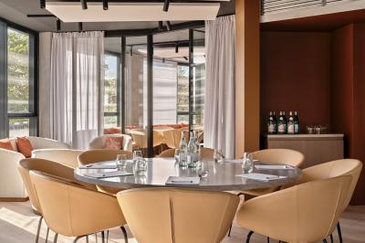 Miniature Salle Longchamp Façade d'un hôtel moderne avec enseigne lumineuse ’Crowne Plaza’ au crépuscule, entourée de végétation et d'immeubles.