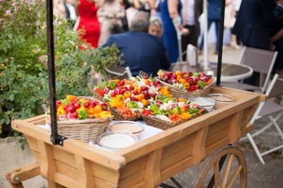 Assiette contenant une mousse verte garnie de persil, accompagnée de tomates rôties et de points de sauce balsamique.