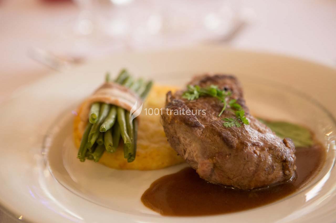 Assiette avec un filet de viande, sauce brune, galette de pommes de terre et fagot de haricots verts liés.