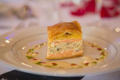 Assiette contenant une mousse verte garnie de persil, accompagnée de tomates rôties et de points de sauce balsamique.