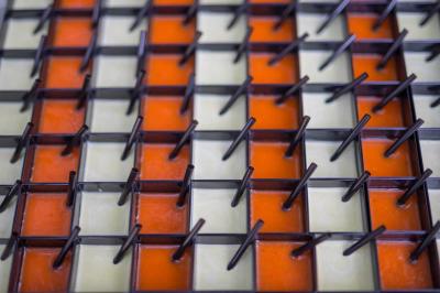 Assiette contenant une mousse verte garnie de persil, accompagnée de tomates rôties et de points de sauce balsamique.