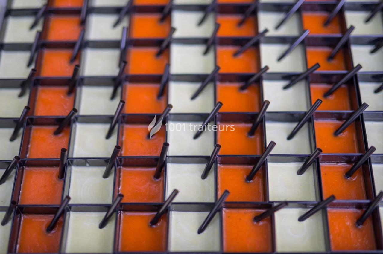 Grille métallique avec des tiges verticales, posée sur des carreaux orange et beige en alternance.