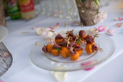 Assiette contenant une mousse verte garnie de persil, accompagnée de tomates rôties et de points de sauce balsamique.