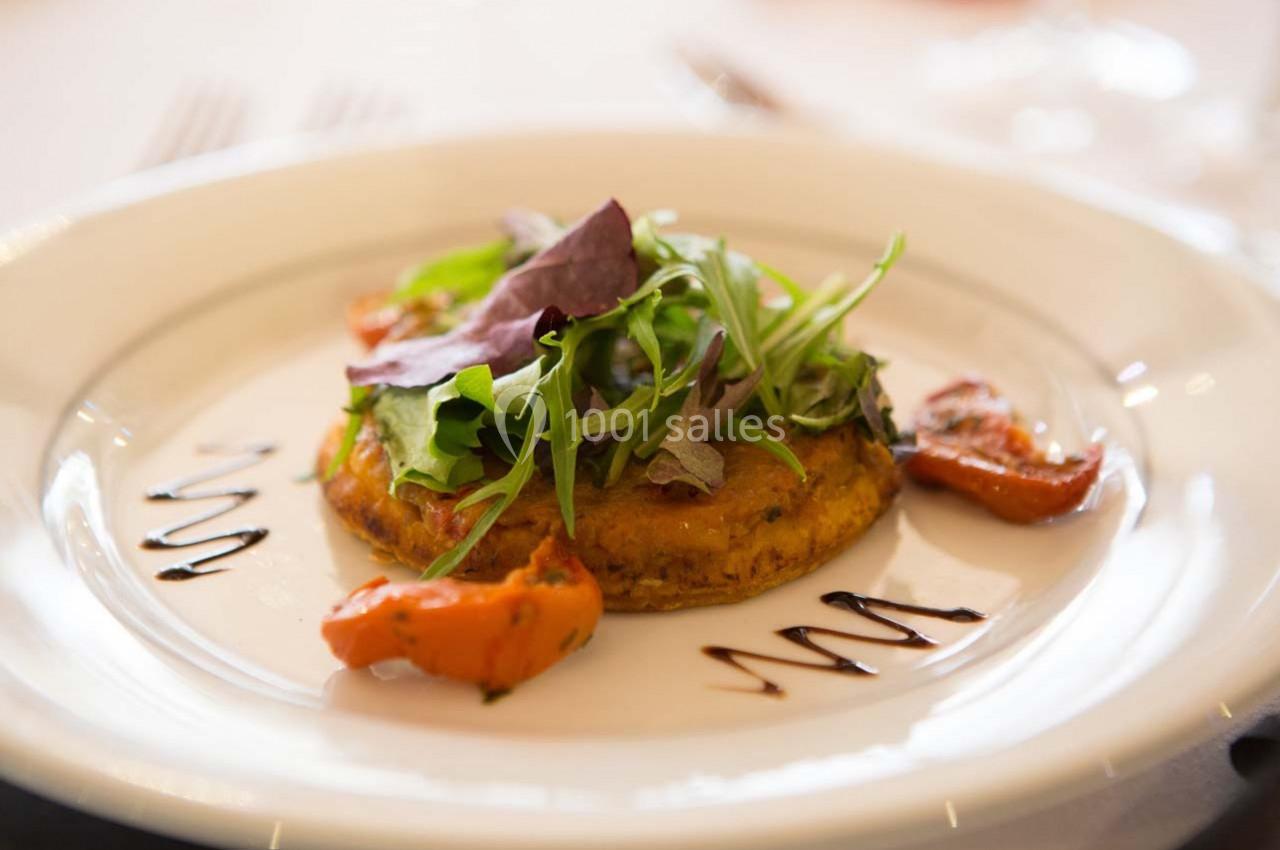 Assiette contenant une tartelette garnie de légumes grillés, de salade verte et de filet de vinaigre balsamique.