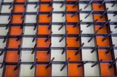 Assiette contenant une mousse verte garnie de persil, accompagnée de tomates rôties et de points de sauce balsamique.