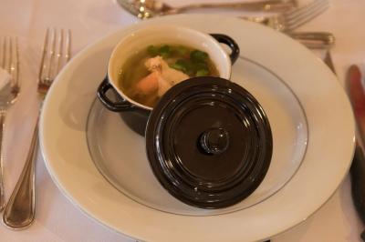 Assiette contenant une mousse verte garnie de persil, accompagnée de tomates rôties et de points de sauce balsamique.