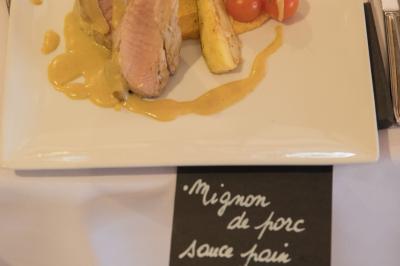 Assiette contenant une mousse verte garnie de persil, accompagnée de tomates rôties et de points de sauce balsamique.