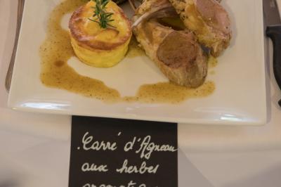 Assiette contenant une mousse verte garnie de persil, accompagnée de tomates rôties et de points de sauce balsamique.