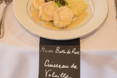 Assiette contenant une mousse verte garnie de persil, accompagnée de tomates rôties et de points de sauce balsamique.