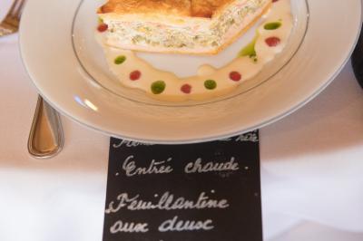Assiette contenant une mousse verte garnie de persil, accompagnée de tomates rôties et de points de sauce balsamique.