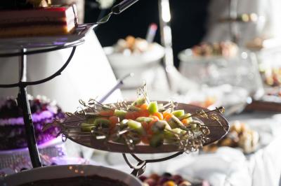 Assiette contenant une mousse verte garnie de persil, accompagnée de tomates rôties et de points de sauce balsamique.