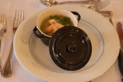 Assiette contenant une mousse verte garnie de persil, accompagnée de tomates rôties et de points de sauce balsamique.
