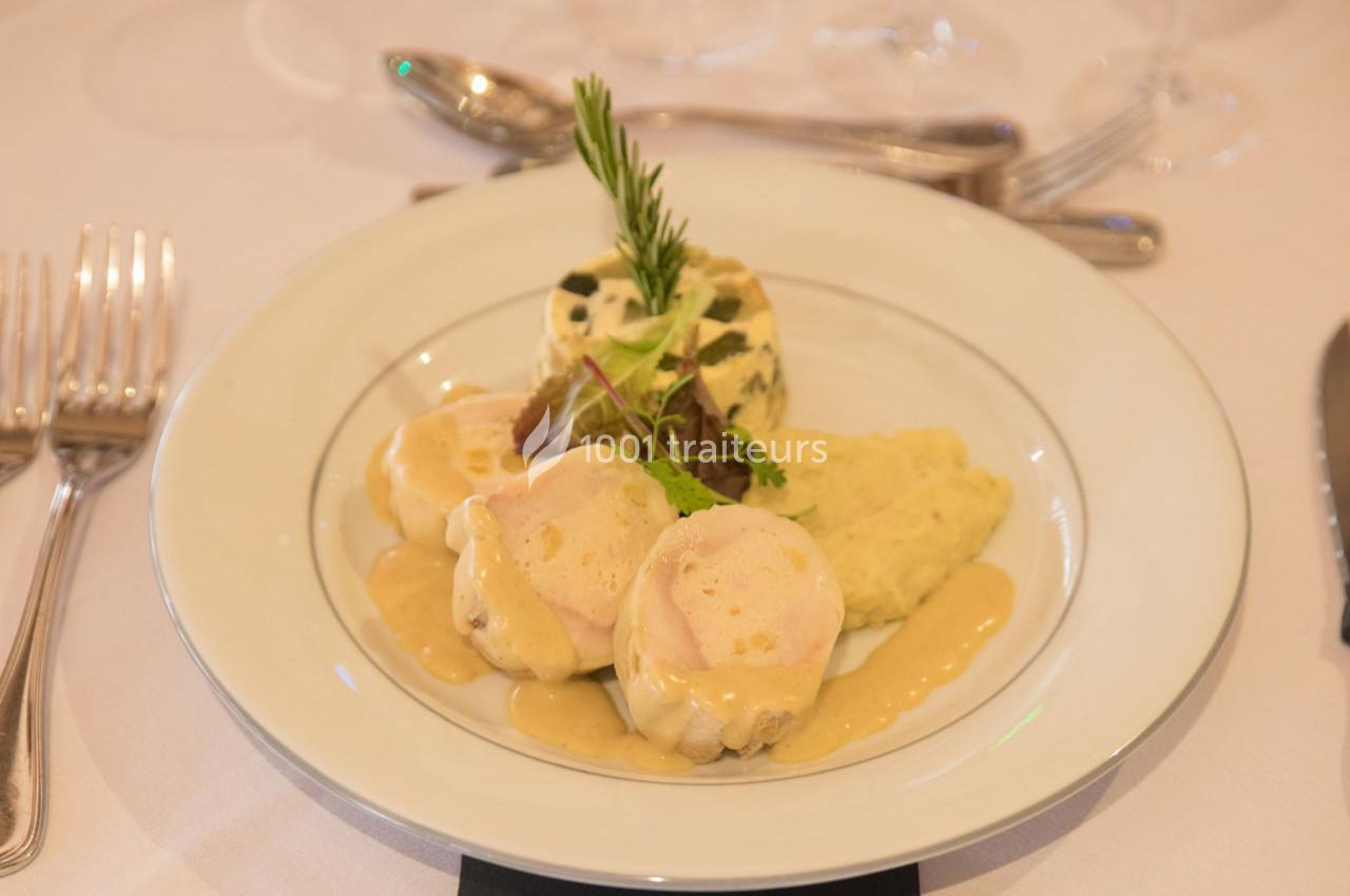 Assiette de médaillons de volaille nappés de sauce, accompagnés de purée et d'un flan aux herbes.