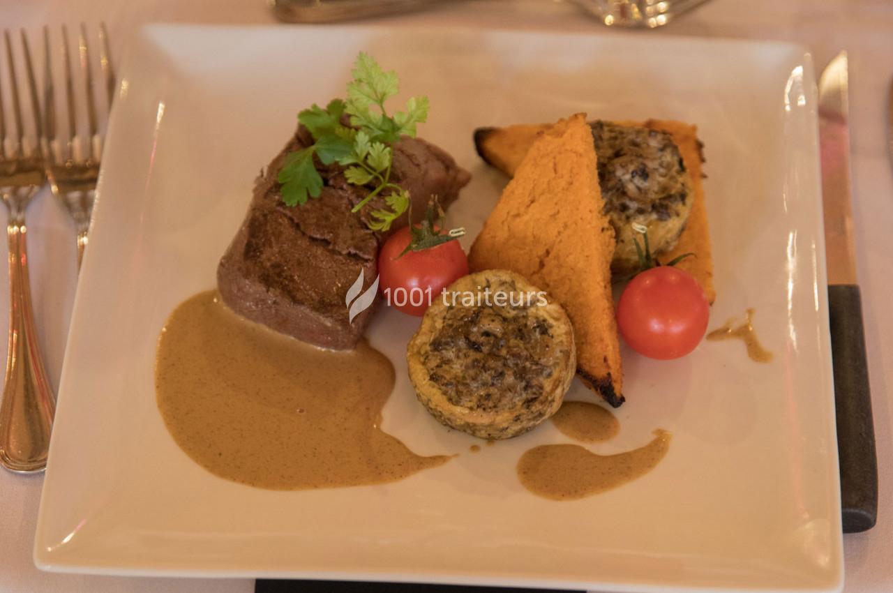 Assiette composée d'un filet de viande, sauce, légumes grillés, tomates cerises et garniture aux champignons.