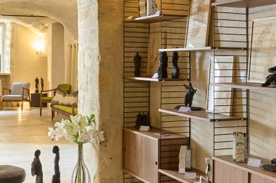 Salle de réunion avec tables disposées en U, chaises noires, bouteilles d'eau et écran de projection allumé.