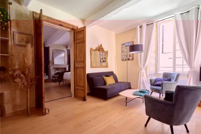 Salle de réunion avec tables disposées en U, chaises noires, bouteilles d'eau et écran de projection allumé.