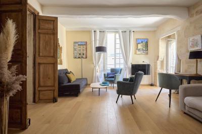Salle de réunion avec tables disposées en U, chaises noires, bouteilles d'eau et écran de projection allumé.