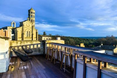 Salle de réunion avec tables disposées en U, chaises noires, bouteilles d'eau et écran de projection allumé.