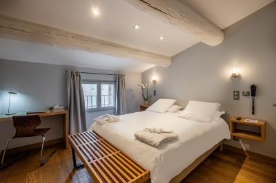 Salle de réunion avec tables disposées en U, chaises noires, bouteilles d'eau et écran de projection allumé.
