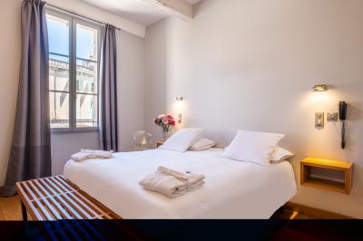 Salle de réunion avec tables disposées en U, chaises noires, bouteilles d'eau et écran de projection allumé.