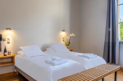 Salle de réunion avec tables disposées en U, chaises noires, bouteilles d'eau et écran de projection allumé.