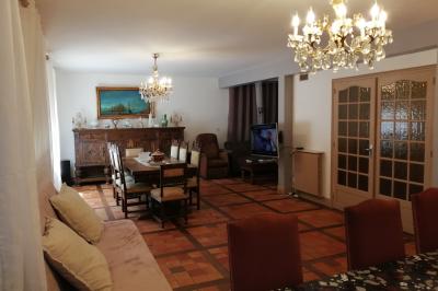 Salle de réception décorée avec des guirlandes et des lumières colorées, des invités assis et dansant.