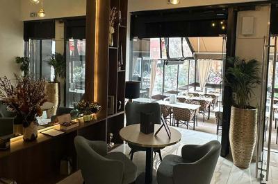 Façade d'un restaurant avec l'inscription ’1847 Restaurant-Lounge’, partiellement cachée par des feuilles vertes au premier…