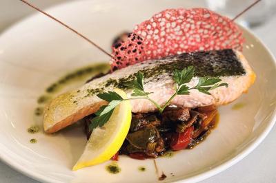 Façade d'un restaurant avec l'inscription ’1847 Restaurant-Lounge’, partiellement cachée par des feuilles vertes au premier…