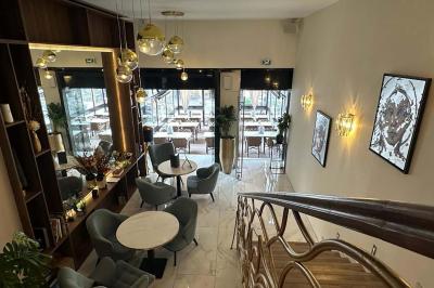 Salle de restaurant moderne avec tables dressées, chaises bleues, éclairage tamisé et bar illuminé en arrière-plan.