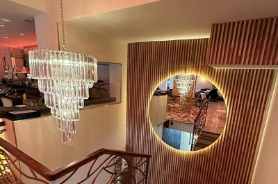 Salle de restaurant moderne avec tables dressées, chaises bleues, éclairage tamisé et bar illuminé en arrière-plan.