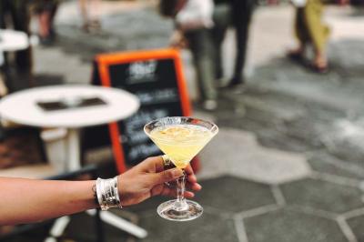 Salle de restaurant moderne avec tables dressées, chaises bleues, éclairage tamisé et bar illuminé en arrière-plan.