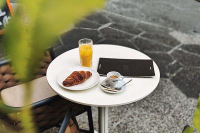 Salle de restaurant moderne avec tables dressées, chaises bleues, éclairage tamisé et bar illuminé en arrière-plan.