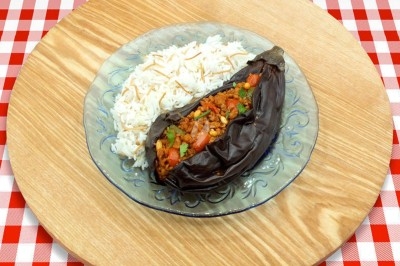 Assiette de wraps garnis autour d'un bol de sauce blanche, accompagnée de légumes marinés et de tranches de tomate.