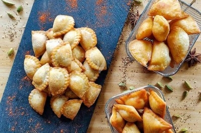 Assiette de wraps garnis autour d'un bol de sauce blanche, accompagnée de légumes marinés et de tranches de tomate.