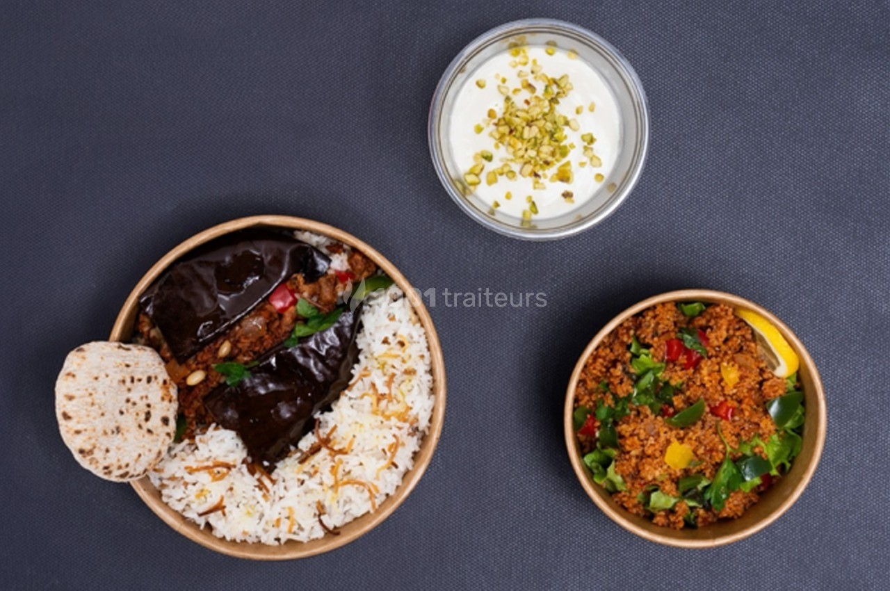 Assiette de riz avec aubergines farcies, bol de taboulé coloré et verrine de yaourt garnie de pistaches.