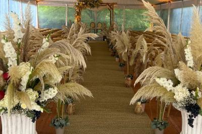 Table dressée avec des chaises transparentes, ornée de compositions florales tropicales colorées et de bougies.