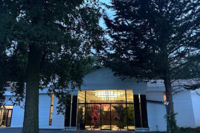Table dressée avec des chaises transparentes, ornée de compositions florales tropicales colorées et de bougies.