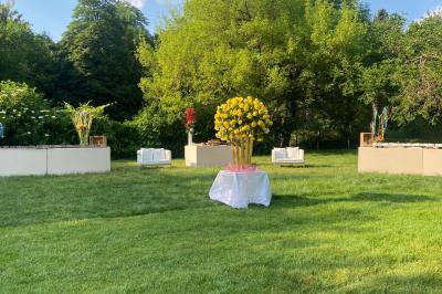 Table dressée avec des chaises transparentes, ornée de compositions florales tropicales colorées et de bougies.