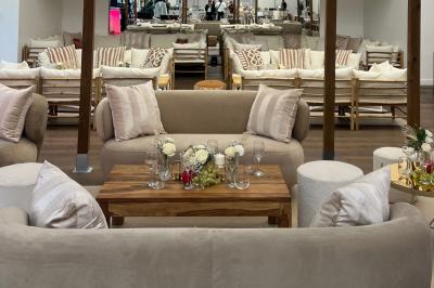 Table dressée avec des chaises transparentes, ornée de compositions florales tropicales colorées et de bougies.