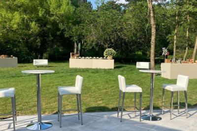 Table dressée avec des chaises transparentes, ornée de compositions florales tropicales colorées et de bougies.