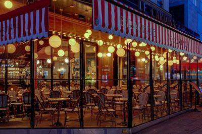 Un liquide enflammé est versé d'une petite carafe dans un verre rempli de glaçons sur une table.
