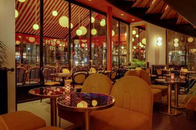 Un liquide enflammé est versé d'une petite carafe dans un verre rempli de glaçons sur une table.